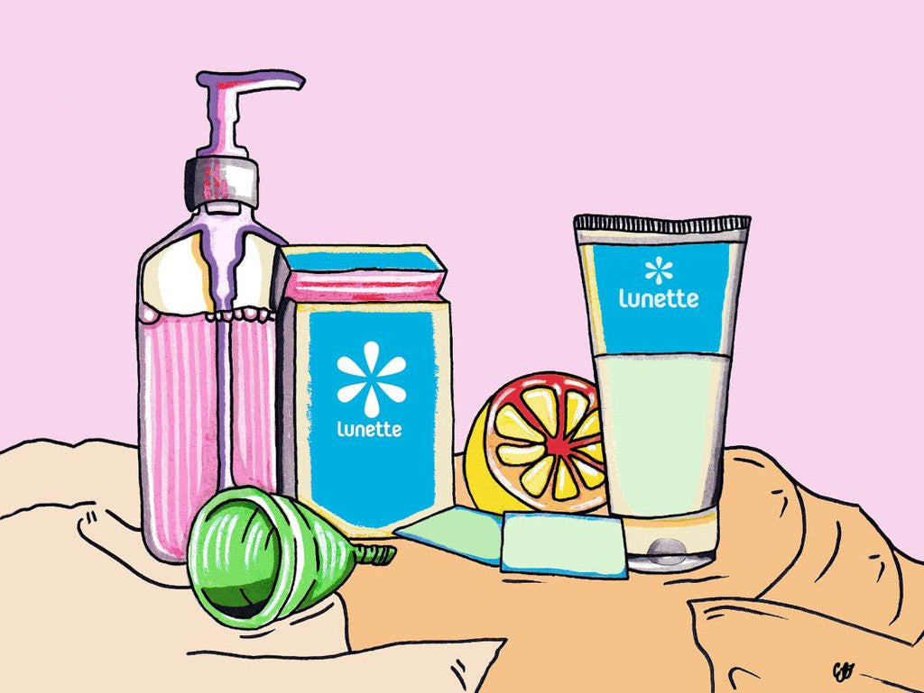 A period cup surrounded by suitable cleaning products including Lunette cup wipes.