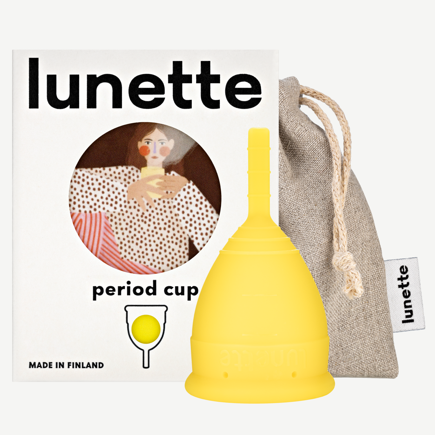 A yellow Lunette period cup displayed alongside its packaging box with a floral design and a linen storage pouch. The box includes the text 'period cup', 'made in Finland', and the brand name 'Lunette'.
