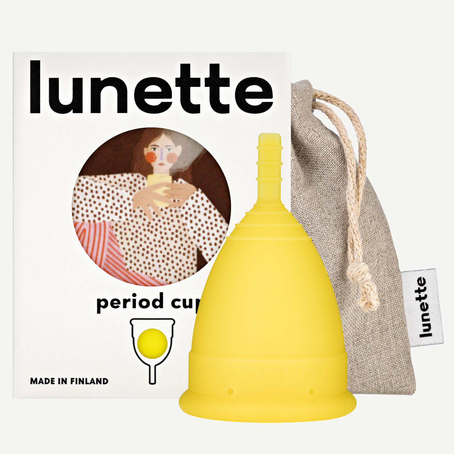 A yellow Lunette period cup displayed alongside its packaging box with a floral design and a linen storage pouch. The box includes the text 'period cup', 'made in Finland', and the brand name 'Lunette'.